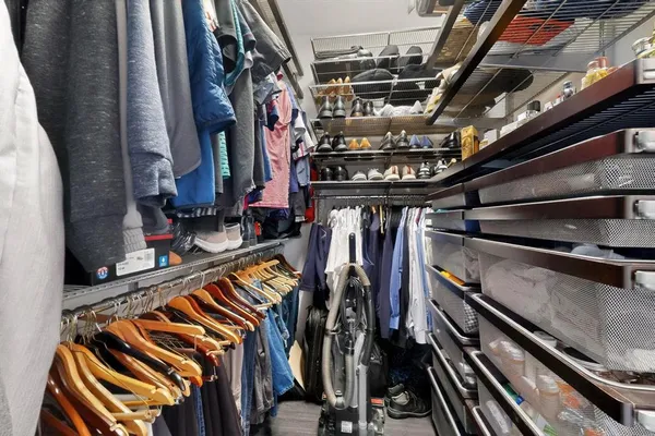 a view of walk in closet with clothes and shoes
