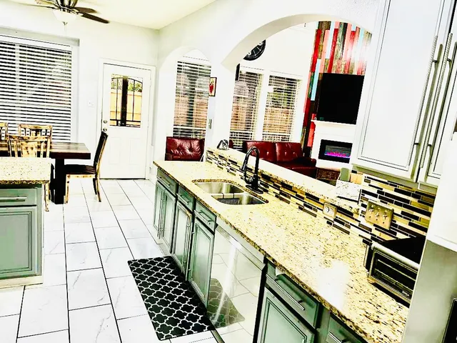 a kitchen with stainless steel appliances kitchen island granite countertop a refrigerator and a stove top oven