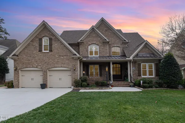 a front view of a house with a yard and a garage