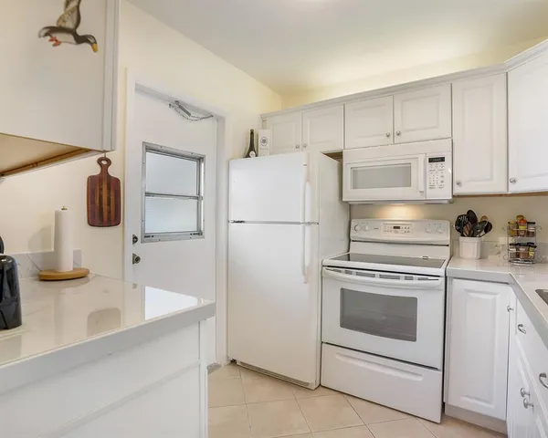 a kitchen with a refrigerator stove and white cabinets