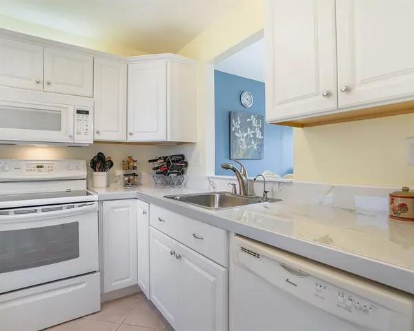 a kitchen with cabinets appliances a sink and a counter top
