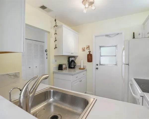 a kitchen with a refrigerator sink and cabinets