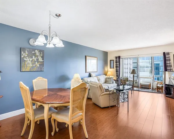 a view of a dining room with furniture wooden floor and chandelier