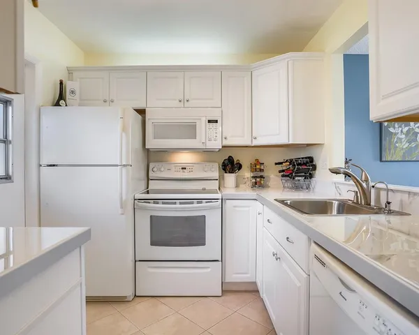 a kitchen with cabinets stainless steel appliances and a sink