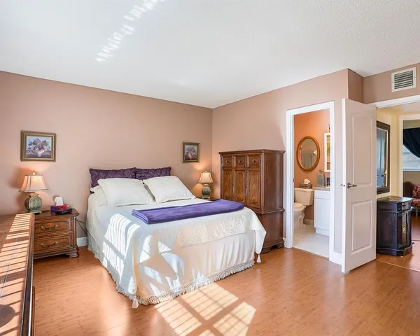 a bedroom with bed and wooden floor