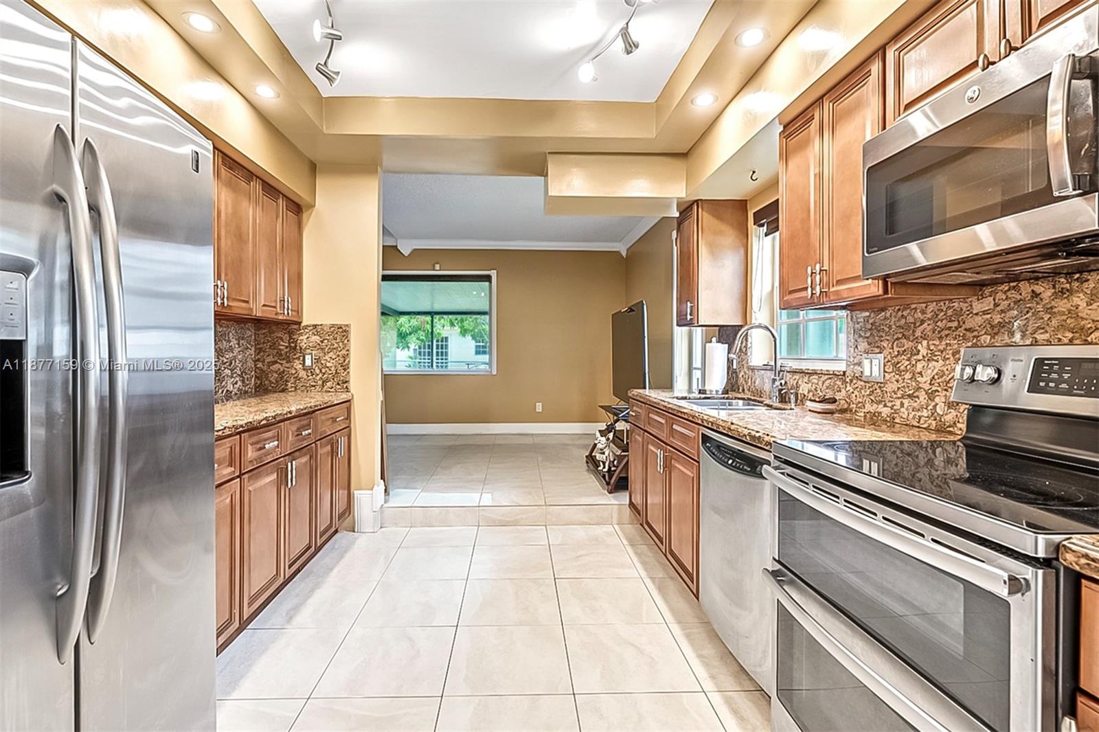 3568 Southwest 69th Way Miramar, FL 33023 - Photo 11 of 32 a kitchen with stainless steel appliances granite countertop a refrigerator a stove and a sink