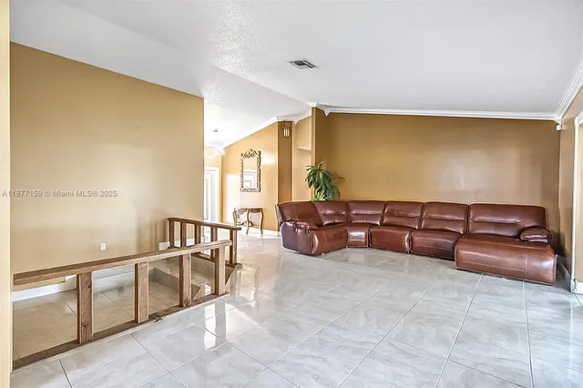 a view of a hallway with wooden floor and a living room
