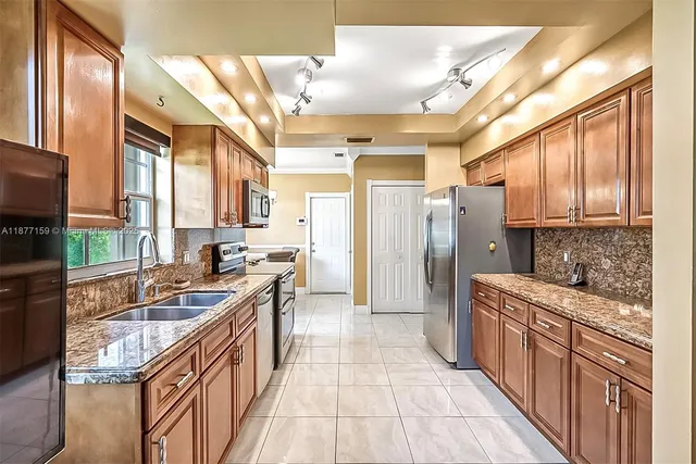 a kitchen with stainless steel appliances granite countertop a refrigerator and a sink
