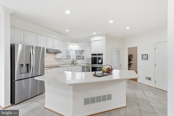 a kitchen with white cabinets and appliances