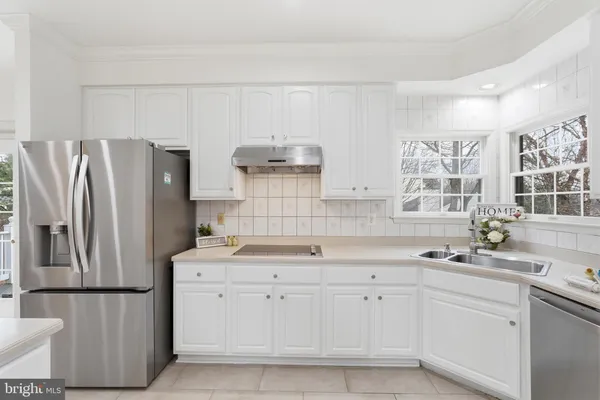 a kitchen with stainless steel appliances granite countertop a sink and a refrigerator
