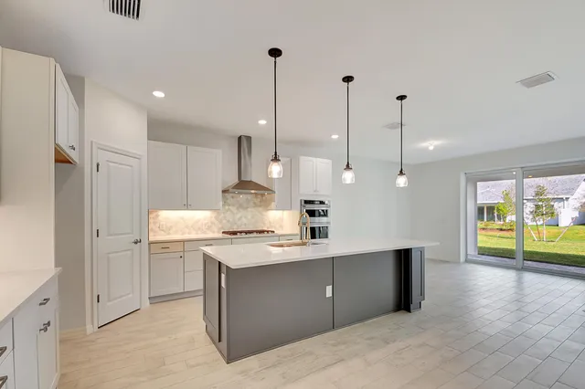 a kitchen with kitchen island a counter top space appliances and a wooden floor