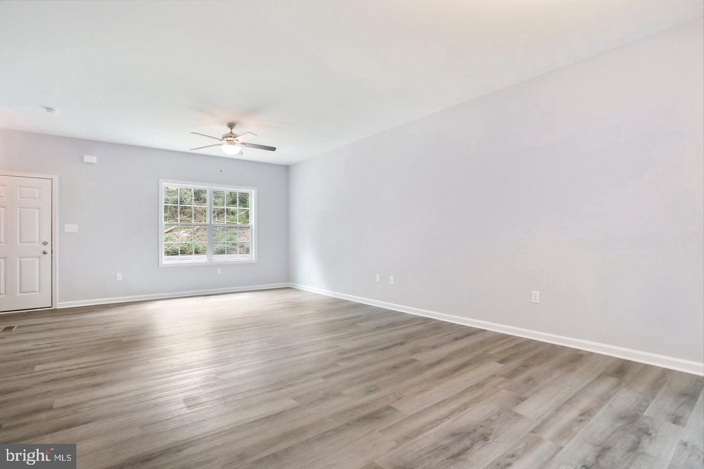 Plum Tree Lane Berkeley Springs, WV 25411 - Photo 2 of 18 an empty room with wooden floor and window