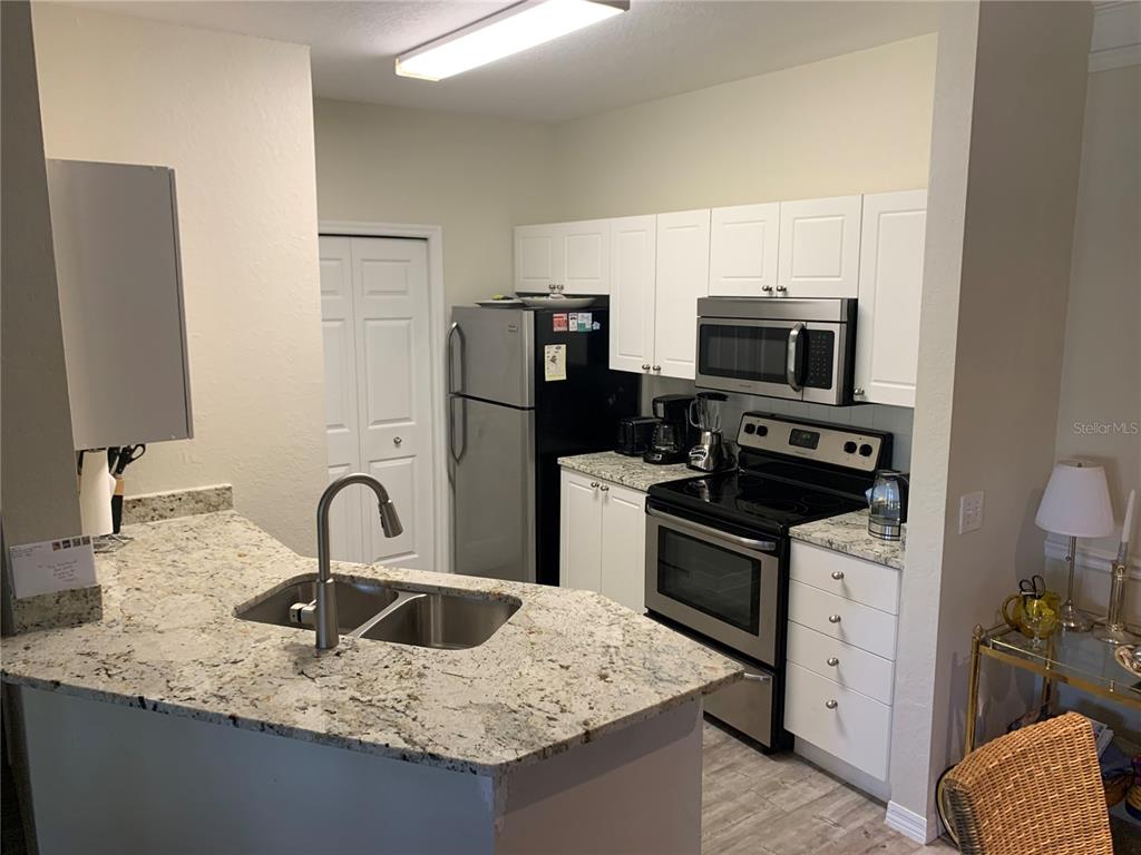 5134 Northridge Road, Unit 204 Sarasota, FL 34238 - Photo 12 of 21 a kitchen with stainless steel appliances granite countertop a sink stove and refrigerator