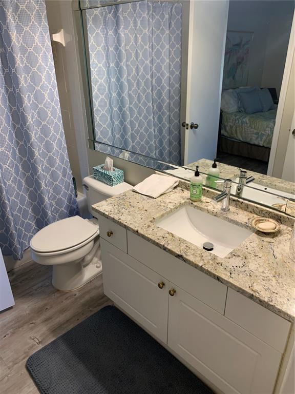 5134 Northridge Road, Unit 204 Sarasota, FL 34238 - Photo 14 of 21 a bathroom with a granite countertop sink a toilet and a mirror