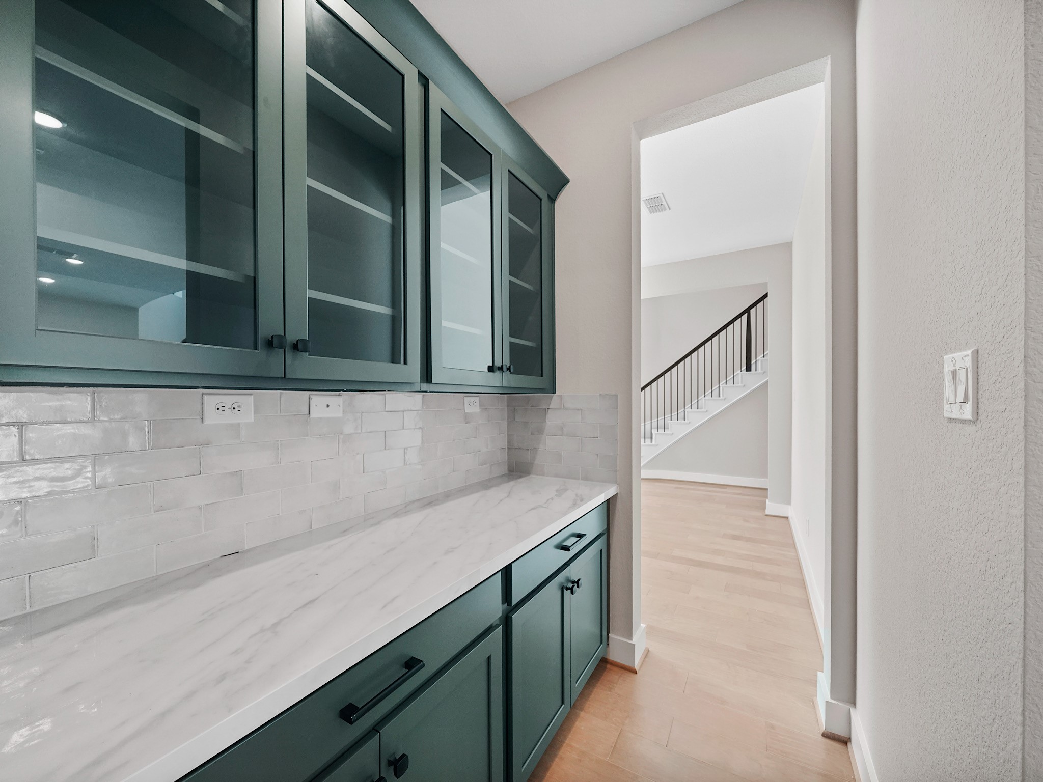 30214 Crossfield Road Fulshear, TX 77441 - Photo 9 of 42 From the dining room, a well-appointed butler’s pantry with glass-front cabinetry creates an elegant transition to the kitchen and generous cabinet space!