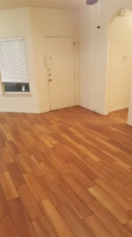 a view of an empty room with wooden floor