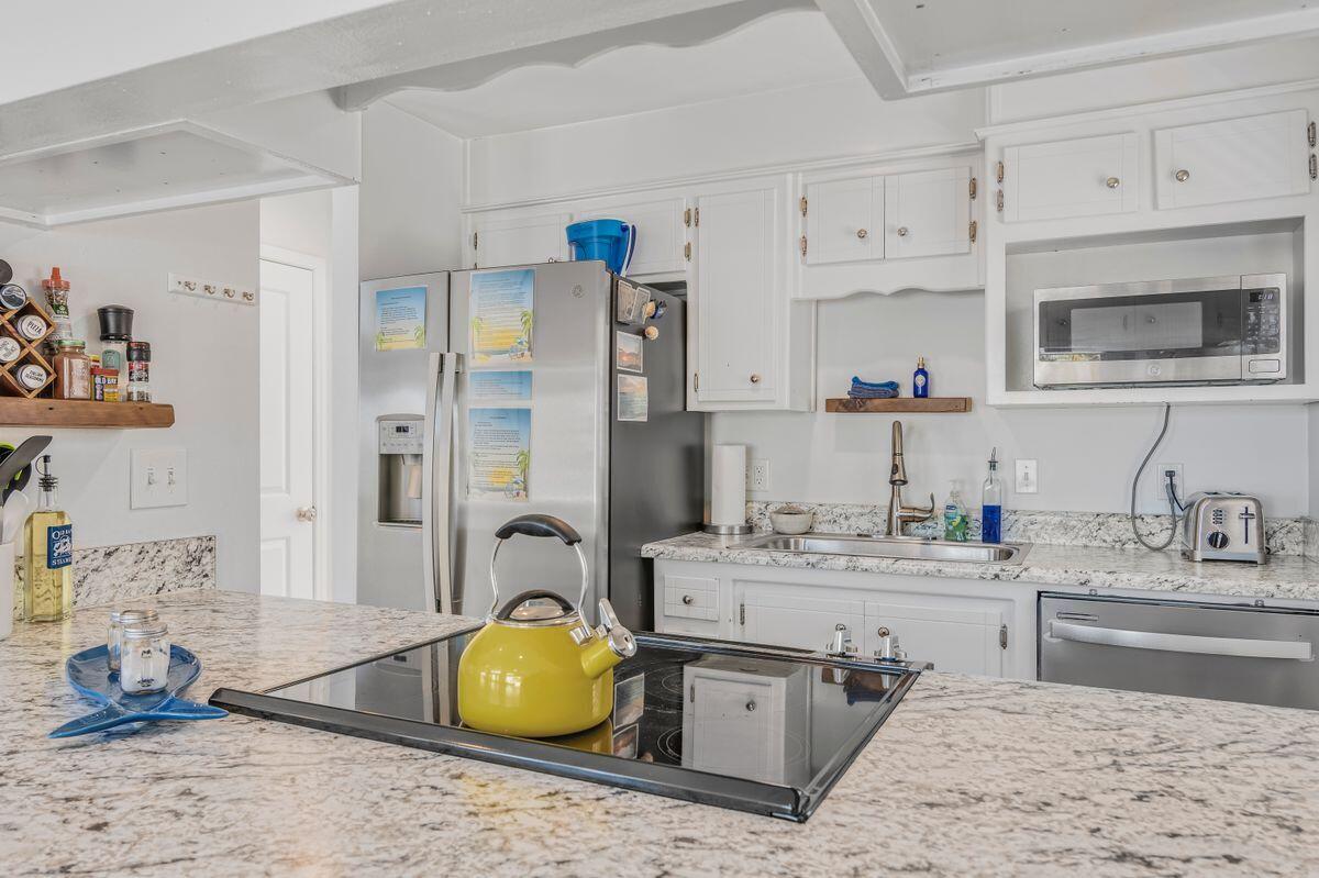 320 Gulf Shore Drive Destin, FL 32541 - Photo 15 of 46 a kitchen with a sink cabinets and stainless steel appliances