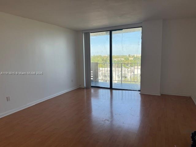 2350 Northeast 135th Street, Unit 711 North Miami, FL 33181 - Photo 2 of 10 a view of an empty room with wooden floor and a window