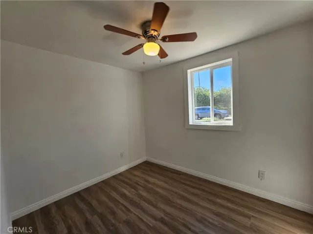 a view of room with window ceiling fan and hardwood floor