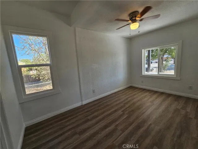 a view of an empty room and window and wooden floor