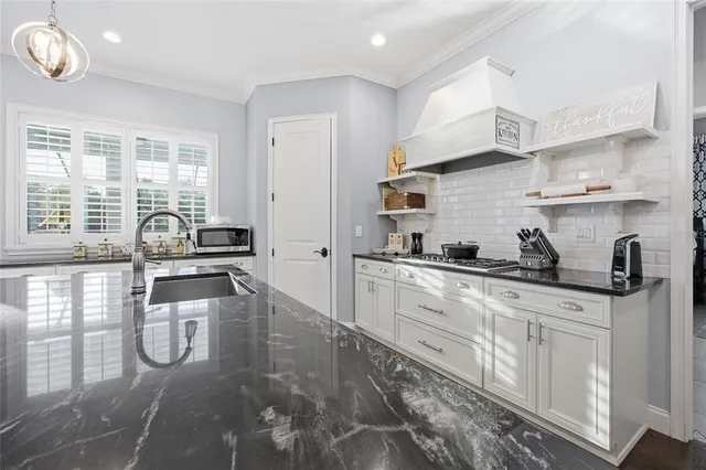 a kitchen with stainless steel appliances granite countertop a sink stove and cabinets