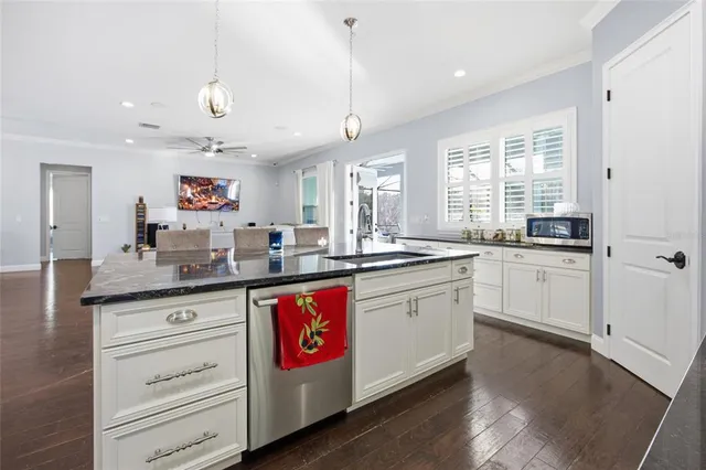a kitchen with granite countertop white cabinets and white appliances