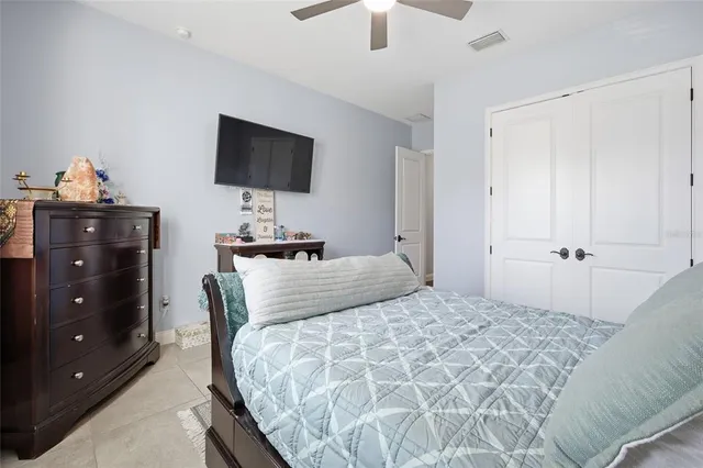 a bedroom with a bed and a flat tv screen on dresser