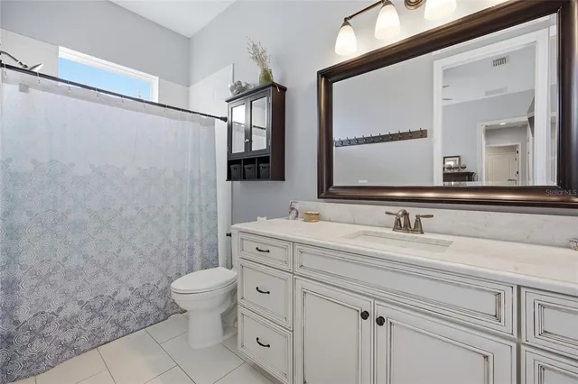 a bathroom with a granite countertop sink a toilet and a mirror