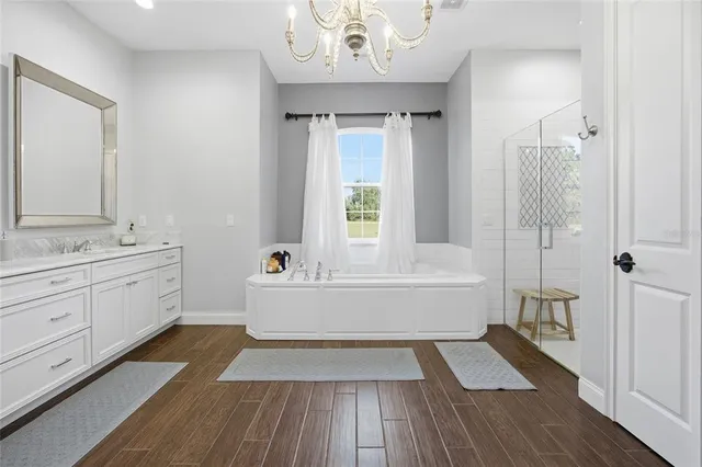 a spacious bathroom with a tub shower and a sink