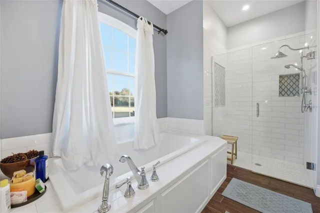 a bathroom with a tub sink and mirror