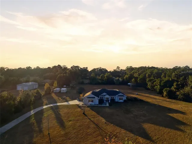 an aerial view of a house with a yard and garden