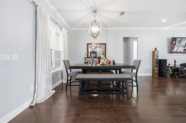 a view of a dining room with furniture wooden floor and a chandelier