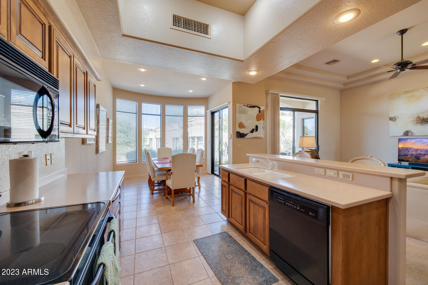 25603 North Sago Drive Rio Verde, AZ 85263 - Photo 3 of 25 a large kitchen with stainless steel appliances a stove a sink dishwasher and a dining table with the living room view