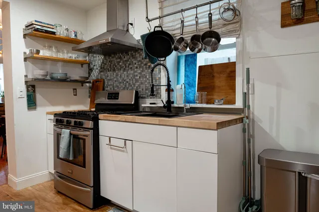 a kitchen with stainless steel appliances granite countertop a sink a stove and a microwave