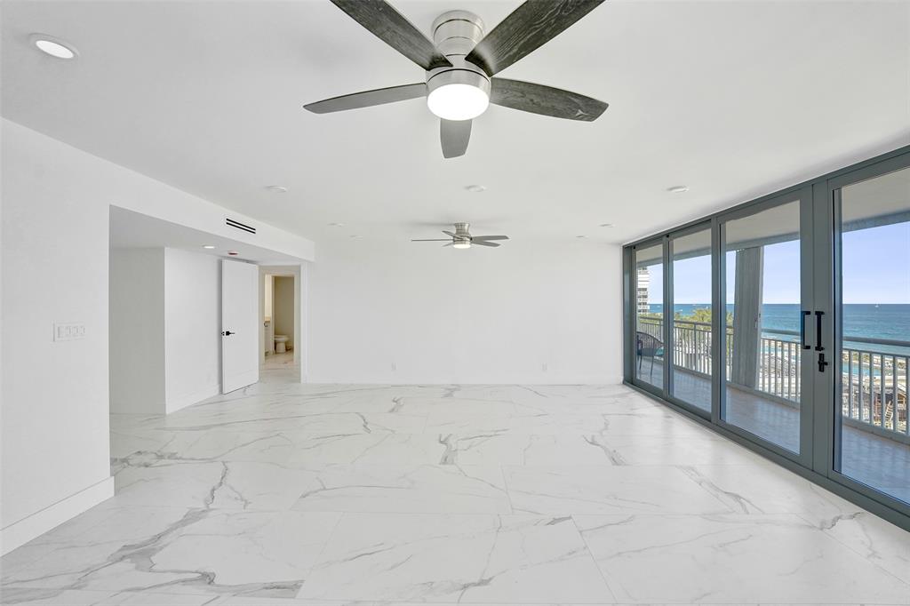 1390 South Ocean Boulevard, Unit 5C Pompano Beach, FL 33062 - Photo 11 of 35 an empty room with chandelier fan and windows