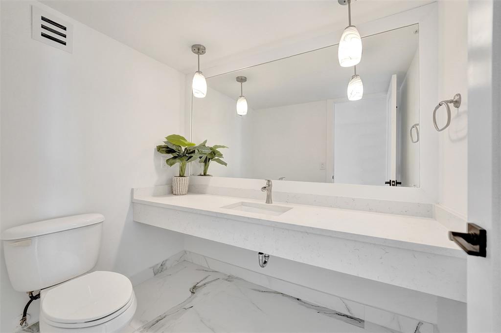 1390 South Ocean Boulevard, Unit 5C Pompano Beach, FL 33062 - Photo 12 of 35 a bathroom with a sink a toilet and a mirror