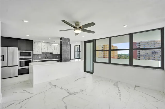 a view of kitchen with refrigerator and white cabinets