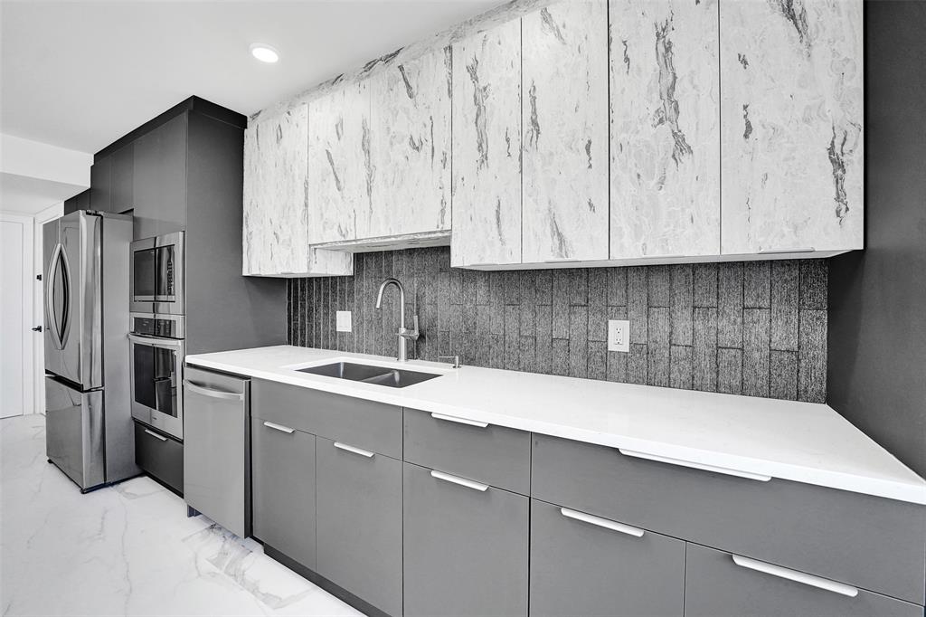 1390 South Ocean Boulevard, Unit 5C Pompano Beach, FL 33062 - Photo 20 of 35 a kitchen with a sink cabinets and stainless steel appliances