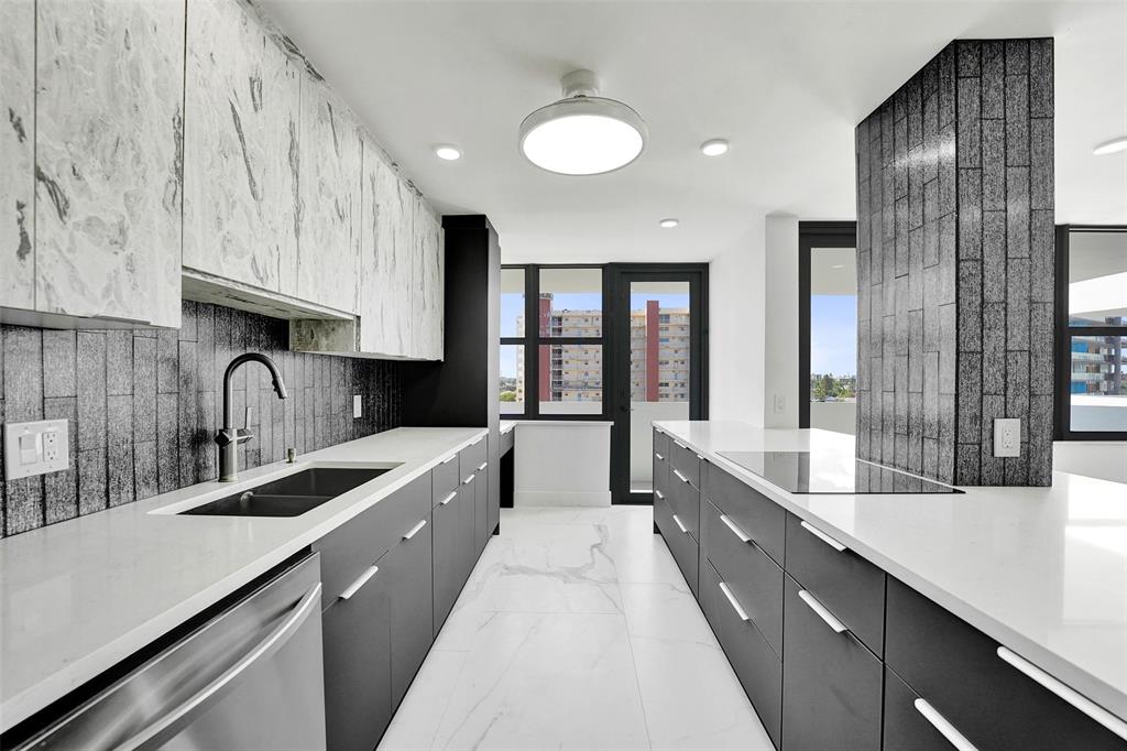 1390 South Ocean Boulevard, Unit 5C Pompano Beach, FL 33062 - Photo 21 of 35 a large kitchen with granite countertop a sink stainless steel appliances and cabinets