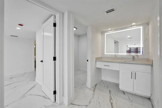 a bathroom with a granite countertop sink a toilet and a mirror