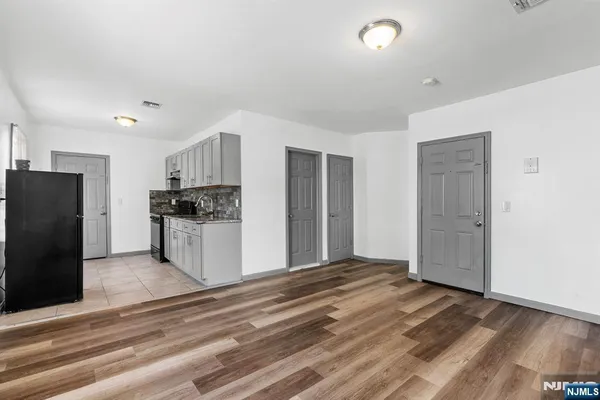 a view of kitchen with refrigerator cabinets and wooden floor