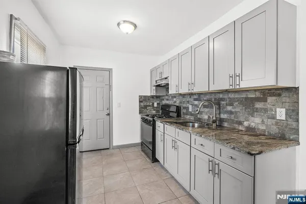 a kitchen with stainless steel appliances granite countertop a refrigerator and a stove top oven