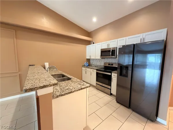 a kitchen with stainless steel appliances granite countertop a refrigerator and a stove