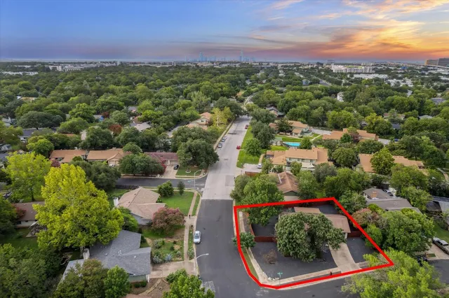 an aerial view of residential houses with outdoor space and trees