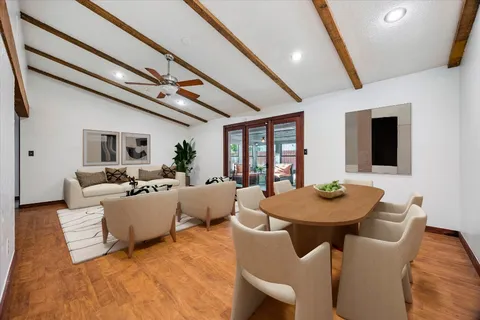 a living room with furniture a flat screen tv and a dining table