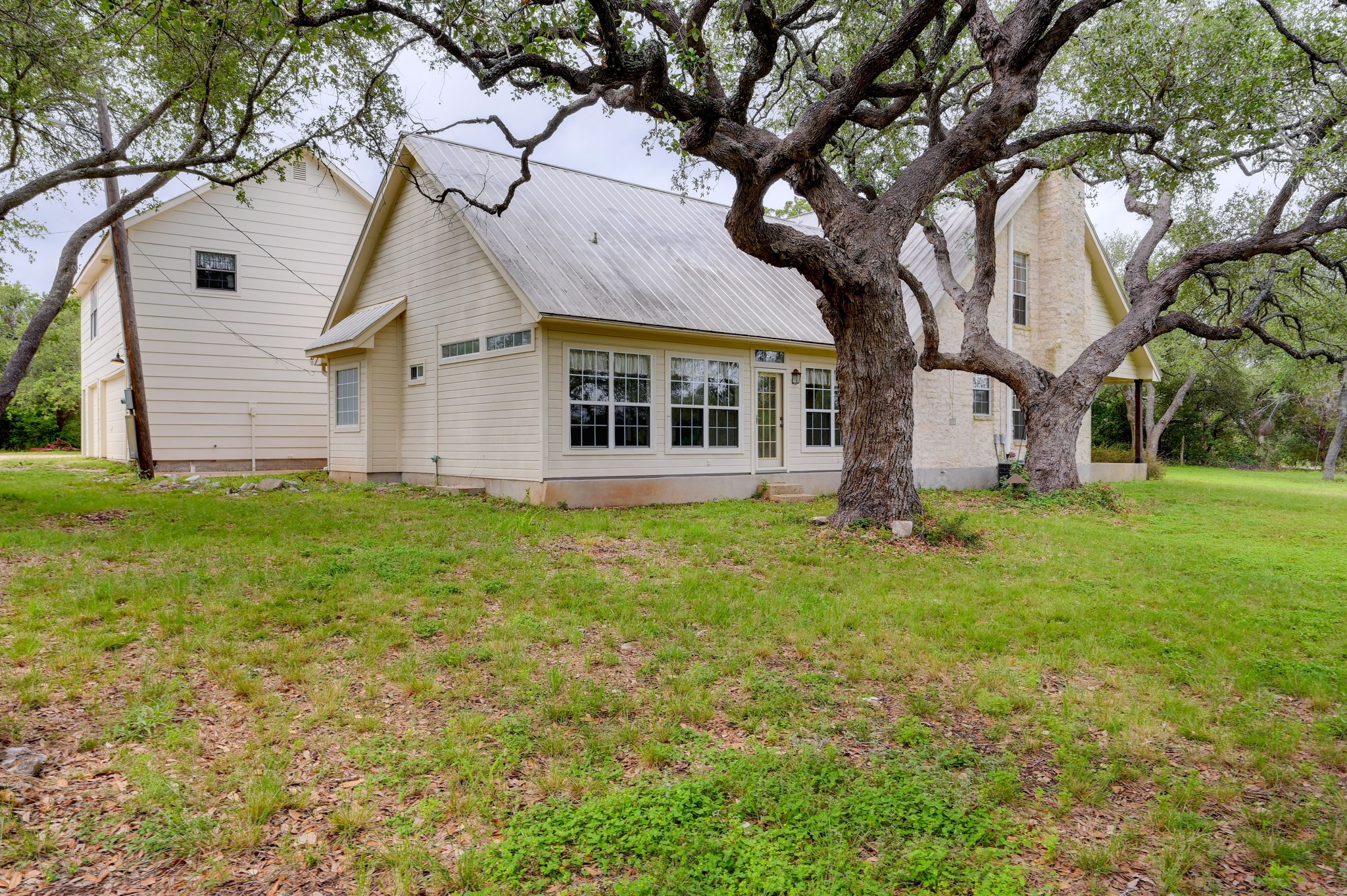 364 Nameless Road Driftwood, TX 78619 - Photo 29 of 32 Mature trees frame this charming residence, offering serene outdoor living with ample green space.