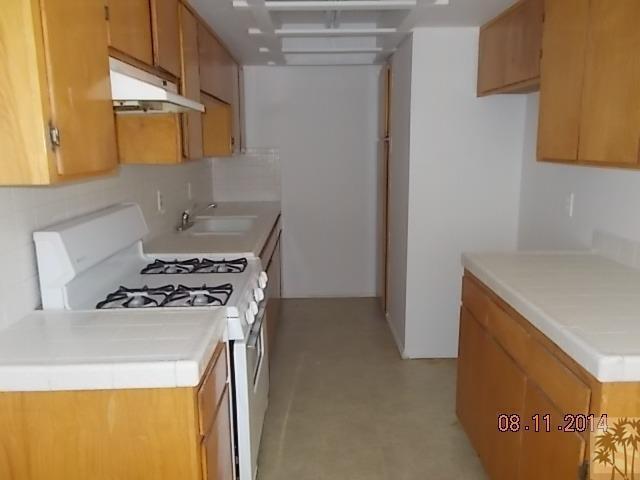 11522 Mesquite Avenue, Unit 2 Desert Hot Springs, CA 92240 - Photo 3 of 6 a kitchen with a stove and a refrigerator