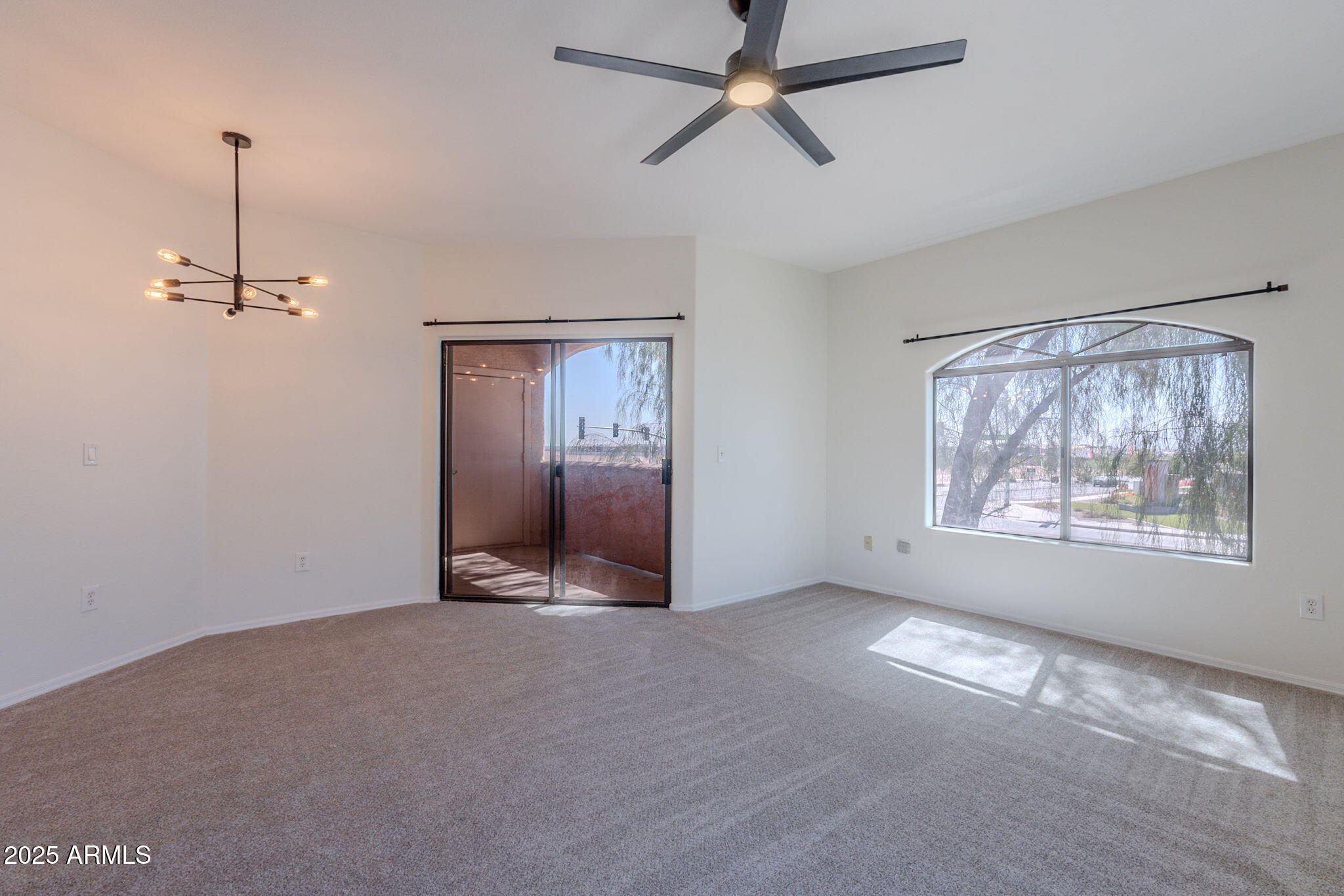 10030 West Indian School Road, Unit 218 Phoenix, AZ 85037 - Photo 11 of 28 a view of an empty room with window and chandelier fan