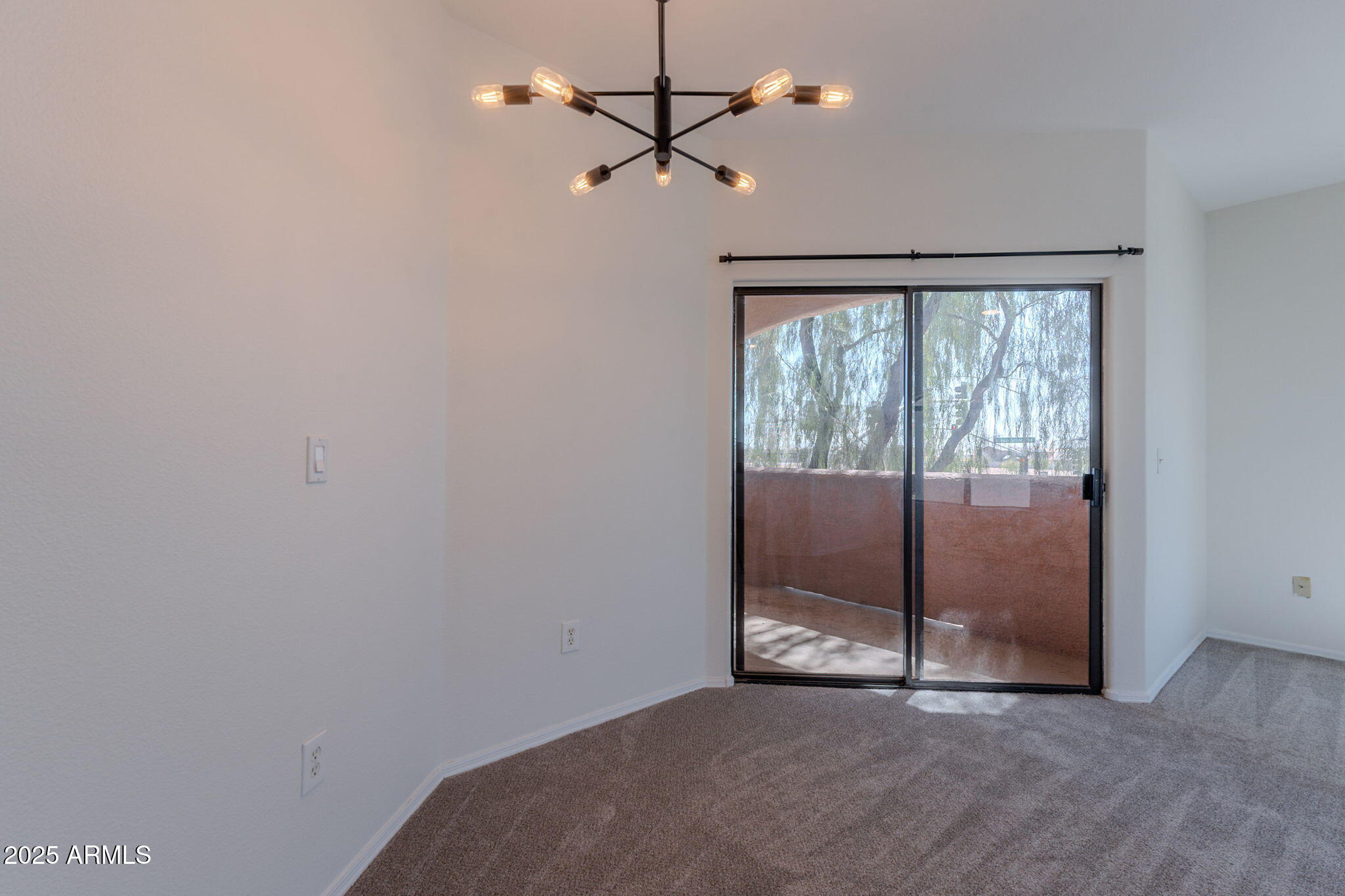 10030 West Indian School Road, Unit 218 Phoenix, AZ 85037 - Photo 12 of 28 an empty room with chandelier fan