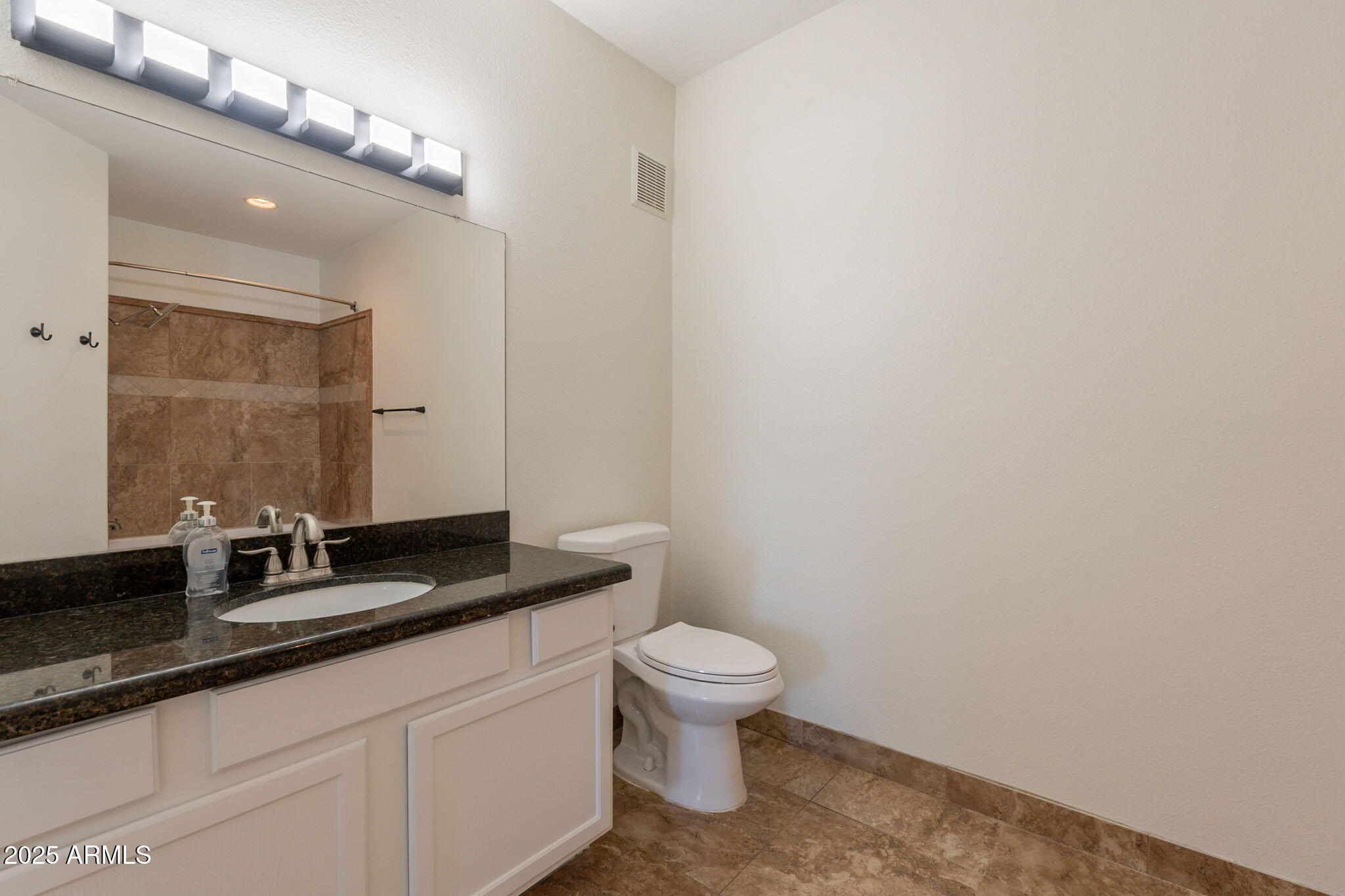 10030 West Indian School Road, Unit 218 Phoenix, AZ 85037 - Photo 21 of 28 a bathroom with a granite countertop sink a toilet and a mirror
